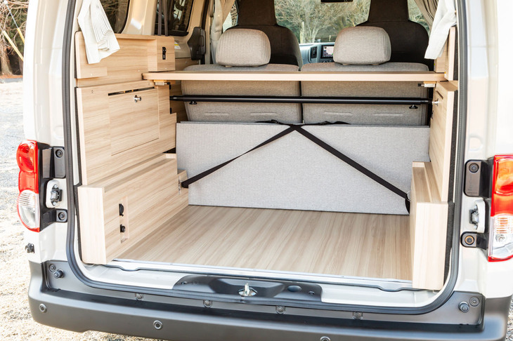 ドライブモード状態をテールゲート側から。床にも壁にもきれいなウッドボードがあしらわれているため、重量物を積む際には養生をお忘れなく。シートの背面に後で紹介するベッド用の板がベルトで固定されている。
