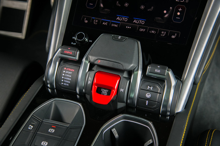 赤いキャップを開けてアクセスするスタート/ストップスイッチは、他のランボルギーニ車と同じ。その左側にはドライブモードセレクターが、右側にはエンジン、ステアリング、サスペンションを個別に設定できるスイッチが並ぶ。