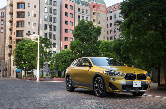 個性的なデザインをまとうBMWの新型SAC「X2」。その姿は、都会の建築群の中でも強烈な存在感を放つ。