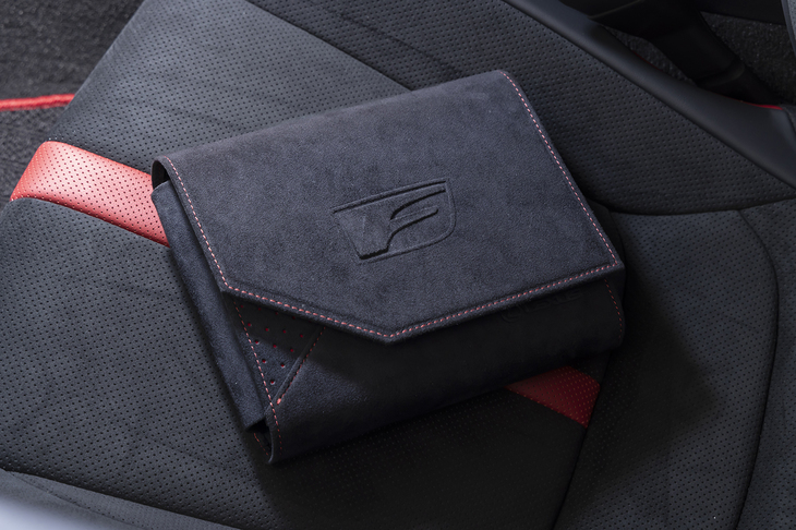 車検証ケースもスペシャル仕立て。素材はウルトラスエードではなくスエード調ファブリックだが、「F」のエンボス加工と赤いステッチがあしらわれている。