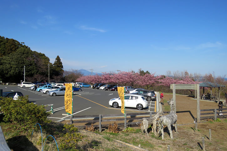 食後の休憩は一夜城歴史公園の駐車場脇にある一夜城ヨロイヅカファームで。陽気に誘われ店外のテーブルでコーヒーを飲む。駐車場にはひっきりなしに観光客のクルマが出入りしていた。真っ白い「リーフ」の後方に相模湾が広がり、その向こうには丹沢山塊のランドマーク、大山が見える。