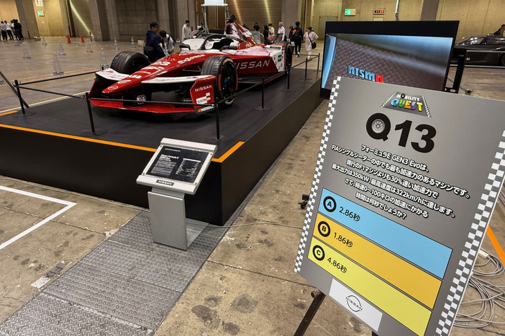 東1～3ホールの「TOKYO GX ACTION」内に展示された「日産フォーミュラE GEN3 Evo」。その脇に設置された「モビリティークエスト」にはフォーミュラEに関するクイズが。「フォーミュラE GEN3 Evoの0-100km/hに加速にかかる時間は何秒？」という問題について、A：2.86秒、B：1.86秒、C：4.86秒の三択で答えを選ぶようになっていた。