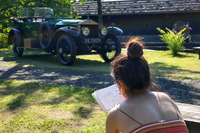 絵本「じどうしゃアーチャー」のモデルになった1919年型「ロールス・ロイス・シルバーゴースト」を熱心にスケッチする、地元の女性イラストレーター。