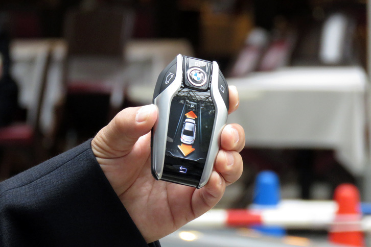 「リモート・パーキング」の操作に用いる「BMWディスプレイ・キー」。画面上の矢印をタッチすることで、車両の前進、後退を操作する。