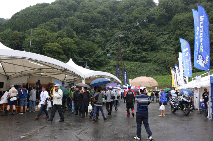 新車の展示スペースやパーツメーカーなどのブースが並ぶエリア。物販ブースにはイベント限定の特価アイテムも見られた。悪天候で到着が遅れた人もいたようで、午後になると一気に人が増え、大いににぎわった。