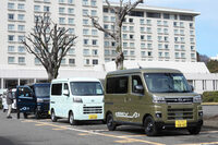 配車スペースにて出発を待つ「e-アトレー」と「e-ハイゼット カーゴ」。競合車種とスペックを比較すると、アトレー／ハイゼットはバッテリー容量が36.6kWhで、電費が161Wh/km、一充電走行距離が257km。対して「三菱ミニキャブEV」はそれぞれ20kWh、127Wh/km、180kmで、「ホンダN-VAN e：」は29.6kWh、127Wh/km、245kmとなっている（電費・一充電走行距離はいずれもWLTCモード）。アトレー／ハイゼットは、車重を重くしてでもバッテリーを多く積み込む、物量作戦で航続距離を稼いでるのだ。