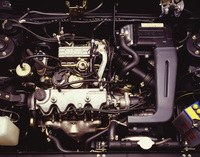 日産で初めてカムシャフトをコッグドベルト駆動とした1.5リッター直4 SOHCのE15E型に換装されたエンジンルーム。エンジンとトランスミッションを直線上に並べるジアコーザ式となり、エンジンが右寄りにオフセットしていることが、ストラットタワーとの位置関係からおわかりいただけるだろう。