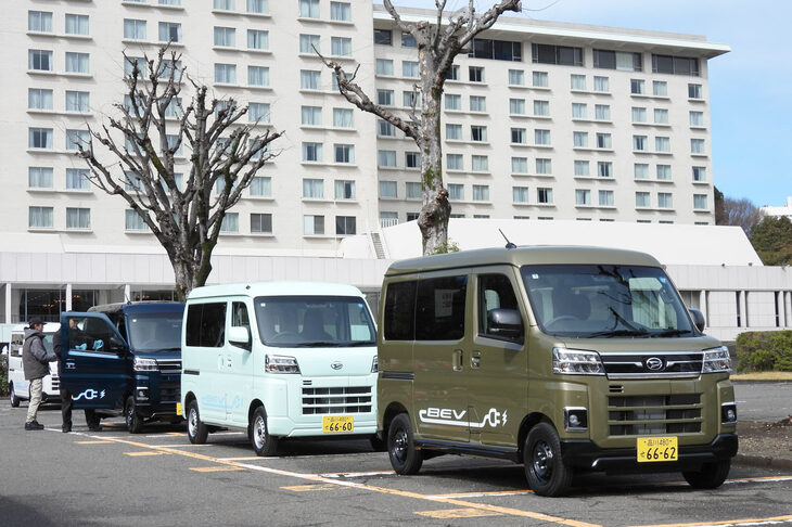 配車スペースにて出発を待つ「e-アトレー」と「e-ハイゼット カーゴ」。競合車種とスペックを比較すると、アトレー／ハイゼットはバッテリー容量が36.6kWhで、電費が161Wh/km、一充電走行距離が257km。対して「三菱ミニキャブEV」はそれぞれ20kWh、127Wh/km、180kmで、「ホンダN-VAN e：」は29.6kWh、127Wh/km、245kmとなっている（電費・一充電走行距離はいずれもWLTCモード）。アトレー／ハイゼットは、車重を重くしてでもバッテリーを多く積み込む、物量作戦で航続距離を稼いでるのだ。