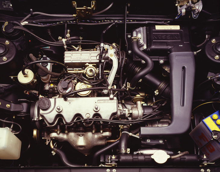 日産で初めてカムシャフトをコッグドベルト駆動とした1.5リッター直4 SOHCのE15E型に換装されたエンジンルーム。エンジンとトランスミッションを直線上に並べるジアコーザ式となり、エンジンが右寄りにオフセットしていることが、ストラットタワーとの位置関係からおわかりいただけるだろう。