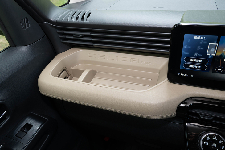 助手席前方の大型トレイはアシストグリップを兼ねている。「DELICA mini」のロゴに加えてステッチ調の加工が施される。