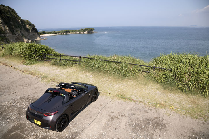 相模湾を眼前に望む「S660 αブルーノレザーエディション」。対岸にはうっすらと江ノ島が見える。