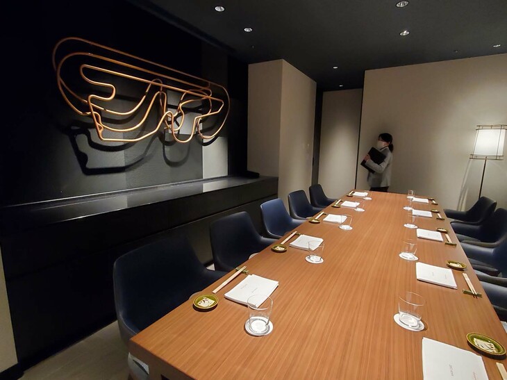 「炉端 OYAMA」の個室。壁面には、改修を重ねてきた富士スピードウェイの、歴代レーシングコースを重ねたオブジェが飾られている。