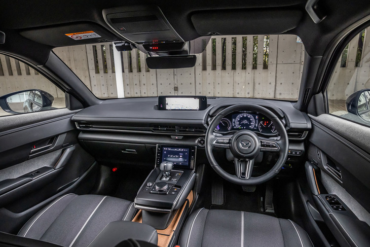 水平基調のインストゥルメントパネルやステアリングホイールなどのデザインは従来型の「MX-30」に準じたもの。メーターや液晶ディスプレイに「ロータリーEV」専用の表示項目が追加される以外に大きな変更はない。