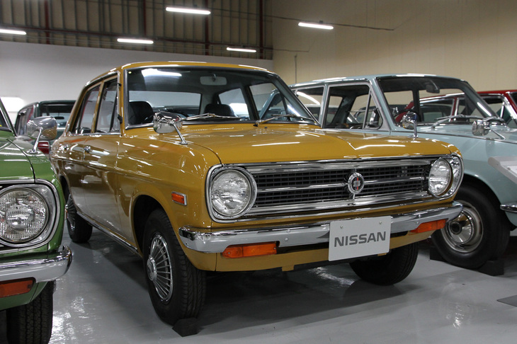 1970年「ダットサン・サニー1200 4ドアデラックス」。型式名B110こと2代目サニーの最量販モデルである4ドアセダン。話題を呼んだ、「隣のクルマが小さく見える」というキャッチフレーズを掲げてデビューした当初の広告やテレビCMに使われていたのが、まさにこのグレード／ボディーカラーだった。