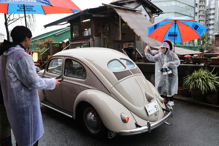 おみやげをもらい、スタッフに見送られるスプリットウィンドウの1951年「フォルクスワーゲン・エクスポートリムジン（タイプ1）」。