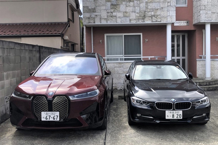 BMWの最新EV「iX」（左）と、2リッター直4ディーゼルターボを搭載する愛車のエリート特急こと「BMW 320d」（右）を並べてみて、あまりのサイズの違いに驚く。