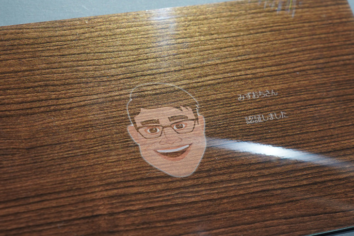 ドライバーの顔認証システムと連動しており、大日本印刷のスタッフが顔を近づけると、「認証しました」の文字とともに似顔絵が表示された。