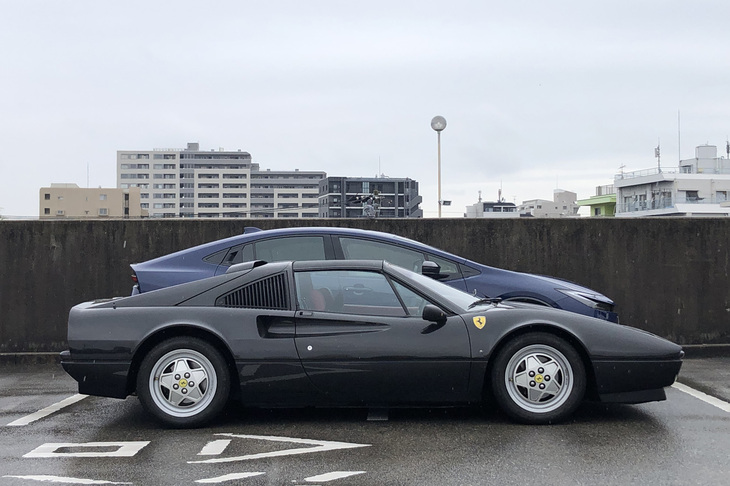 “黒まむしスッポン丸”こと、1989年モデルの愛車「フェラーリ328GTS」（写真手前）と新型「プリウス」（写真奥）を並べてみた。確かにプリウスはスーパーカーみたいなフォルムで、フロントウィンドウは328GTSよりも寝ている。