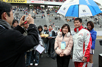 ファンとドライバーの交歓の場である「グリッドウォーク」にて。本山哲の元にはサインや記念撮影を求める長蛇の列ができるが、こうした場で常に率先してファンサービスに努める姿は、さすがエースドライバー。