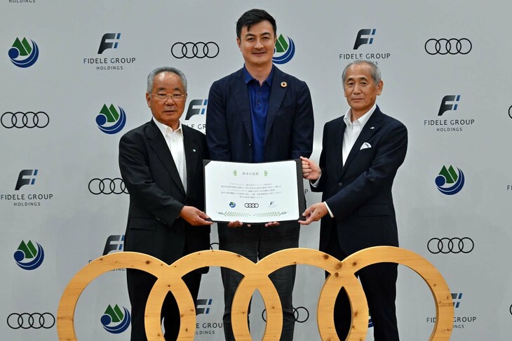 締結した基本合意書を手にするアウディ ジャパンのマティアス・シェーパース氏（中）と荒木耕治屋久島町長（左）、ファーレン九州の金氣重隆社長。