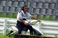 第１ヘアピンでマシンの挙動を確認するためスクーターでやってきたPIAA NAKAJIMAの中嶋悟監督。