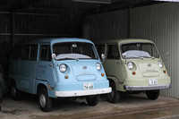 1961年にデビューした初代「スバル・サンバー・ライトバン」。左が65年「ライトバン・スタンダード」、右が64年「同デラックス」で、「デラックス」はワイパーが2本になり、バンパーをはじめ各部にクロムの装飾が付く。どちらもフルオリジナルに近い状態を保った希少な個体である。「あっかんべえ〜」をしているような顔つきから、マニアの間では「あかんべサンバー」とも呼ばれる。