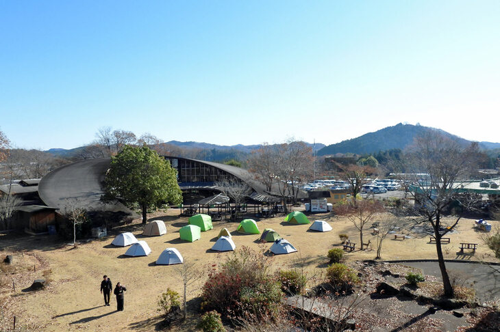 つり橋から見るクラブハウスと「どんぐり広場」の図。この日は、森林の間伐を行う「森づくりワークショップ」のメンバーが、テントを張っていた。