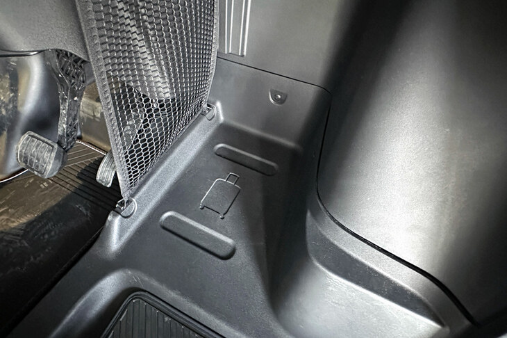 助手席を後方にオフセットすることで生まれた前方足元には、トロリーケースを置くことを示唆するサインが。