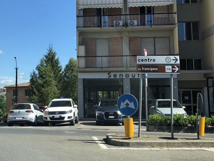 イタリア・シエナにあるセナウトは並行輸入車の販売店。ロータリーに面している。「Senauto」とはシエナの旧名「Saena Iulia」と「auto」による造語である。
