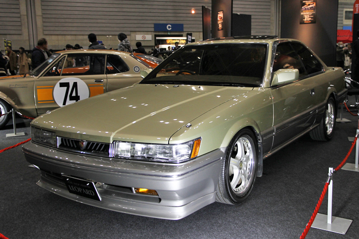 1987年「日産レパード アルティマ」（出展：カーショップフレンド）。TVドラマ『あぶない刑事』の劇用車に使われたこともあって、一部マニアに根強い人気の2代目F31レパード。純正ゴールドのボディーカラーのサンルーフ付きは生産台数30台前後、現存10台以下の希少車とのこと。この個体は内外装フルレストア済みで1512万円。