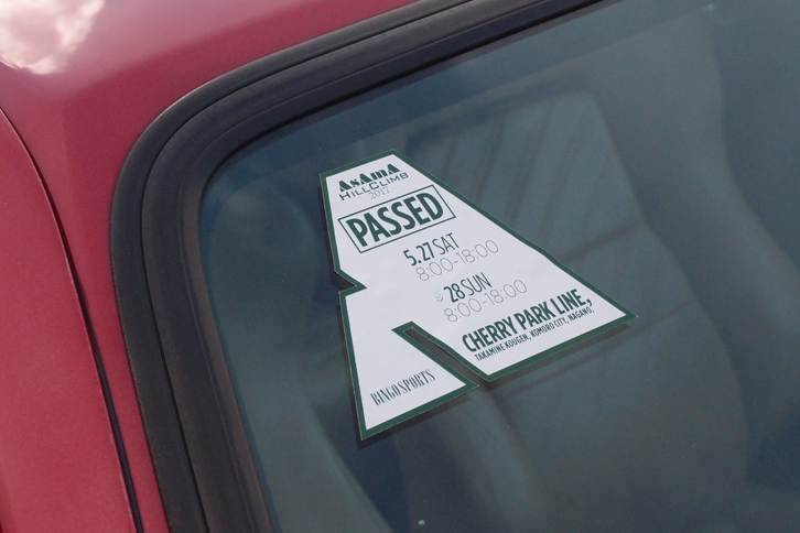 これは、大会の車検をパスしたことを示すシール（フロントガラス部）。出場に際しては、灯火類やけん引フック、ドライバーの服装などがチェックされる。