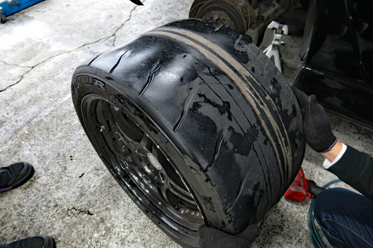 男4人に凝視されるリアタイヤの図。今回も、トレッド面からはベルトがこんにちはである。次はもっと早めに交換しよう……と前回も反省してたな。次こそは、次こそはちゃんとしますから。