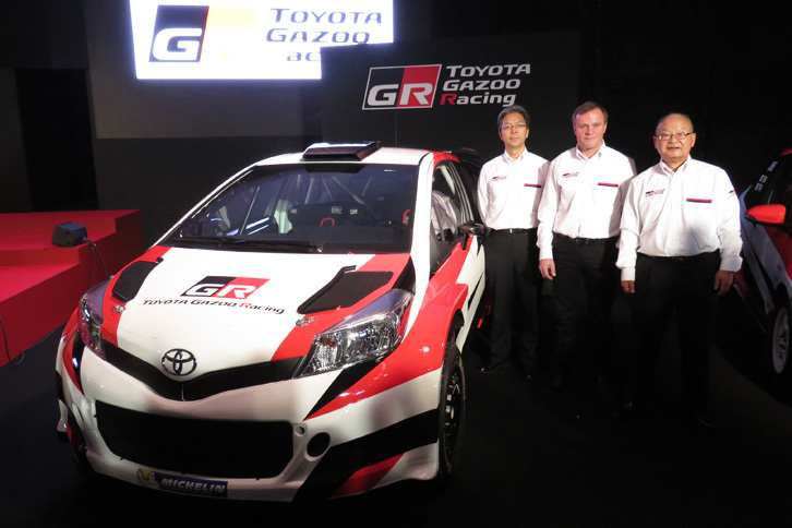 2017年のWRC参戦へ向けて開発が進められている「ヤリス（日本名『ヴィッツ』）」の競技車両と、（写真右から）トヨタの嵯峨宏英専務、トミ・マキネン氏、TMGの佐藤俊男社長。