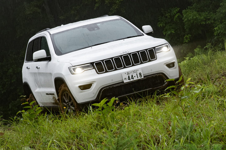 ジープのオフロード試乗会にて、雑草生い茂る急斜面へと臨む「グランドチェロキー」。