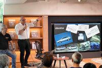 発表会において、日本メーカーとのコラボレーションの歴史を語るベイ氏とポルタ氏。モニターにはいすゞと共同開発したコンセプトカー「アッソ・ディ・フィオーリ」のスケッチと車両製作の様子が映されている。