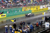 チームのピット前を通過するNo.7のプジョー。ブルデーがマシンのドアを開けてファンに応える。