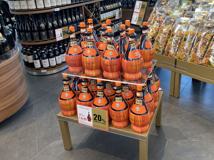 売店ブースで。キャンティワインは昔ながらの藁（わら）が巻かれたタイプだ。1リッターで6.99ユーロ（およそ980円）。