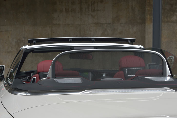 後方からの風の巻き込みを防ぐドラフトストップ（写真手前）。フロントウィンドウ上部のディフレクター（写真奥）とともにオープン走行時の快適性を高める。