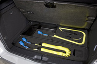 充電ケーブルは、ラゲッジボードの下に収納。ボードの取っ手には、プラグのイラストが添えられる。（写真をクリックすると充電用ケーブルが見られます）