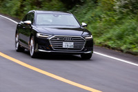 「プレディクティブアクティブサスペンション」を作動させた左コーナーでの走行シーン。室内では水平に近いレベルが維持されているが、外から眺めるとアウト側のサスペンションが伸びてロールが抑えられた様子が確認できる。