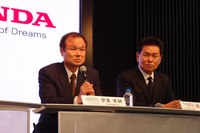 記者団の質問に答える伊東社長。「レースへの参戦は、われわれにとっても楽しみ。ひいては日本全体が元気になることを期待しています」。写真右は、四輪のレースを担当する、本田技術研究所の新井康久専務執行役員。
    