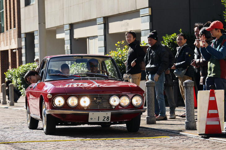 1966年「ランチア・フルヴィア クーペ」のナビゲーターが、“線”を踏むタイミングを見極めるべく大きく身を乗り出している。