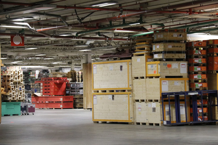 プレスセンターが設営されたパビリオンの半分は空きスペース。ブース設営のための機器を入れる箱が積み上げられていた。