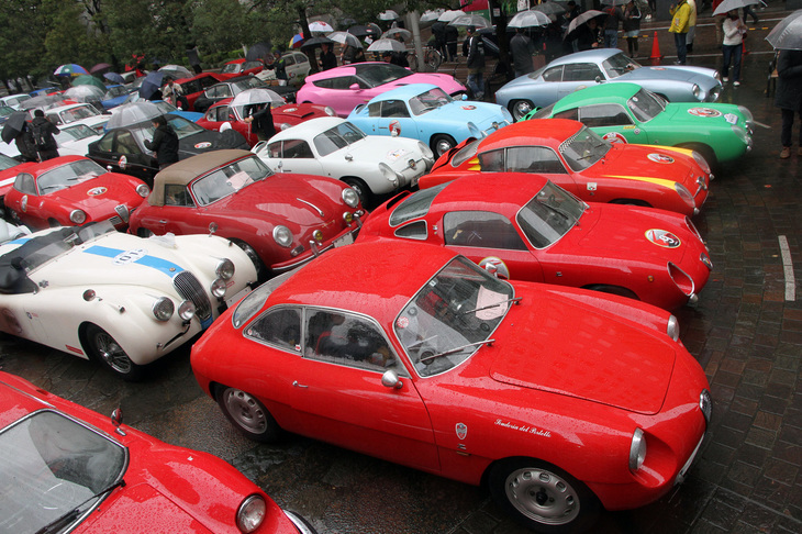 汐留シオサイト5区 イタリア街の中央にある汐留西公園に早朝から集まった参加車両。手前の1959年「アルファ・ロメオSZ」をはじめ、前方（原則としてカーナンバーが若い車両）にはザガートボディーのモデルが多く並んでいる。