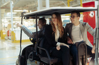 工場見学はゴルフカートに乗って。見られるのは最終アッセンブリーの一部のみだが、貴重な体験なのは間違いない。