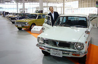 1966年型初代「カローラ」の傍らに立つのは、10代目を担当する奥平総一郎エグゼクティブチーフエンジニア。展示会場では、9台の歴代カローラが年代順にズラリ並べられる。