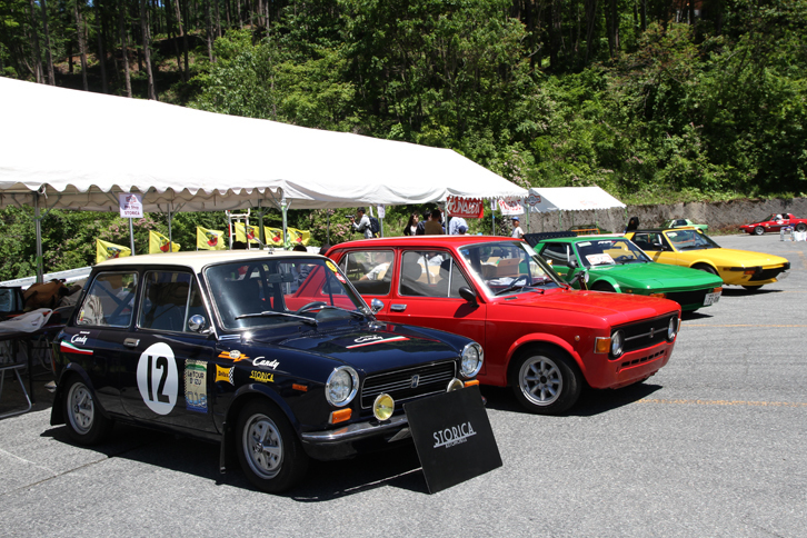 プロショップおよびクラブテントの車両展示。手前から「アウトビアンキA112アバルト」「フィアット128」、そして2台の「フィアットX1/9」。