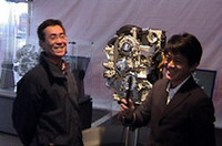 
	【ロータリーエンジンとは】
	世にある一般的な自動車エンジンは、シリンダーの中にあるピストンの往復直線運動で回転力を得るレシプロエンジン。ロータリーエンジンとは、楕円状のローターハウジング内に、三角形のオムスビ型ローターを配し、ローターの回転を直接利用する機構のこと。ローターと壁の間にできる容積がローターの回転とともに変化し、吸入-圧縮-膨張-排気の行程が連続して行われる。
	クランクとバルブがないため、小型で軽量、シンプルな仕組みとなるのがメリット。一方で燃焼室が扁平で完全燃焼がしにくく、またオイル消費量が多いというデメリットもある。量産しているメーカーは、世界でマツダのみ。
	 