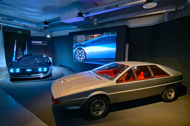 イタルデザインは、新作コンセプトEV「アッソ・ディ・ピッケ・モビメント」のモックアップ（左奥）とともに、その着想の源となった1973年「アッソ・ディ・ピッケ」（右手前）を展示した。