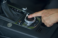 写真中央は、ダイヤル式の「new MMI」のコントローラー。上面の黒い部分はタッチパッドで、指先での文字入力が可能となっている。
    